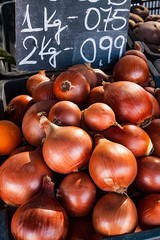 CEBOLLAS Y CARTEL DE PRECIOS EN MERCADO CALLEJERO DE FRUTAS EN MADRID, ESPAÑA