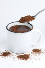 COFFEE CUP WITH COFFEE AN SPOON ON WHITE BACKGROUND