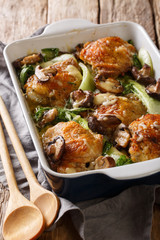 fried chicken thighs with baby bok choy, cheese and mushrooms in Asian style close-up. vertical
