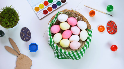Basket with colorful dyed eggs standing on table, Easter atmosphere, inspiration