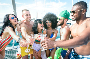 Multiracial friends having fun drinking champagne wine at sail boat party - Friendship concept with...