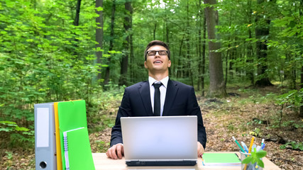 Successful businessman enjoying work in park, good air conditioning in office