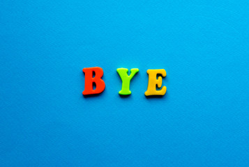 word bye from plastic magnetic letters on blue background