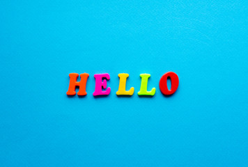 word hello from plastic magnetic letters on blue background