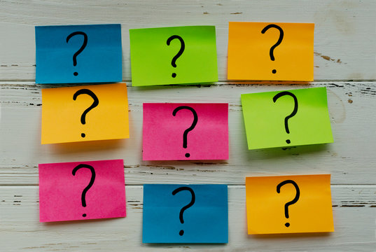 colored stickers with question marks on  white vintage wooden table