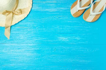  Frame elegant female straw hat slippers on blue wooden background, copyspace for text, summer vacation. © MaximBeykov