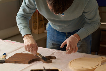 man covers a chopping board with special oil in the production hall