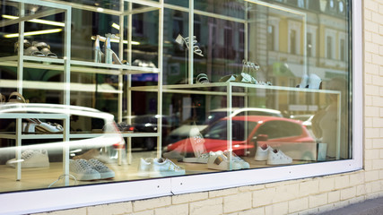Shop window of luxury shoes store, fashionable female, footwear sale, shopping