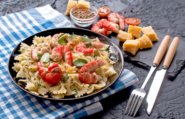 Macaroni with shrimp and cheese slices with stylish Cutlery on black background. Italian cuisine. The concept of healthy eating.