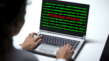 Phishing attack on laptop computer, woman working in office, cybercrime, fraud