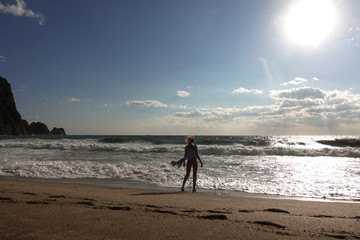 Girl walks into the sea with big waves