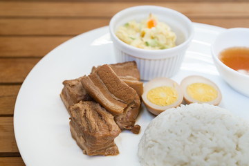 Obraz na płótnie Canvas Braise and roast pork belly meat with stream rice and mash potato salad on white plate and wooden table.