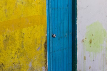 A blue wooden door in a white and yellow wall (Ari Atoll, Maldives)