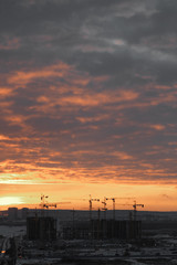 Construction of modern high-rise buildings. Evening and night view of the city.