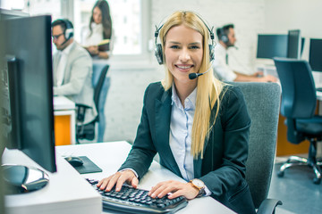 Beautiful blond hair young business woman working in call center as customer support operator