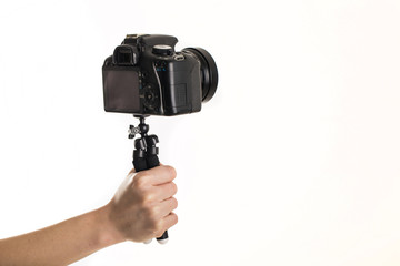 Woman hand and Black DSLR Camera on tripod isolated on white background