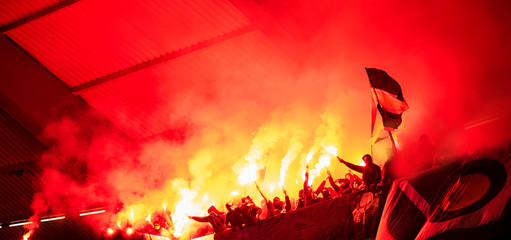 football hooligans with mask holding torches in fire
