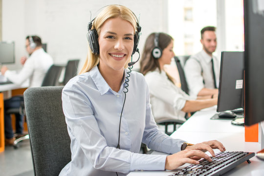 Smiling Customer Support Worker Woman With Headset Working On Computer In Call Center