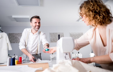 Obraz premium Professional tailors during work on project in fashion design studio, using sewing equipment