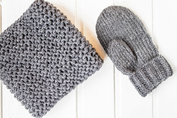 Knitted clothes. Grey mitten and scarf. Flat lay