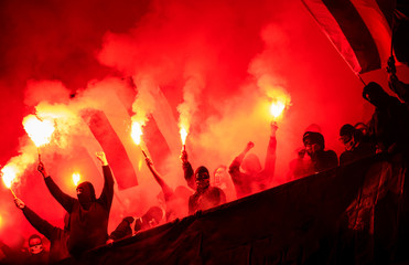 football hooligans with mask holding torches in fire