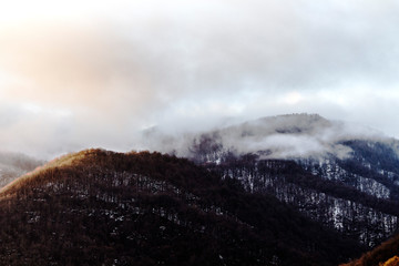 Beautiful winter mountains. White clouds and forest