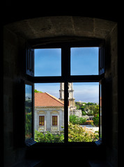 View through the window to medieval clock tower in the city of Rhodes island, Greece.