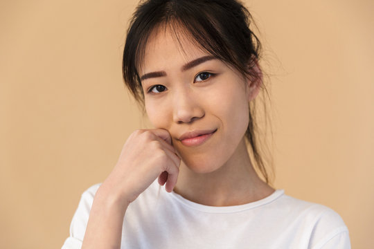 Photo of beautiful korean woman wearing basic t-shirt smiling and looking at camera