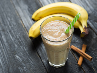 Banana smoothie or banana milkshake on wooden table