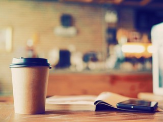 hot coffee on wooden table with sun light morning  from the window.