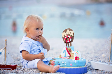 Sweet baby boy, celebrating first birthday with sea theme cake and decoration