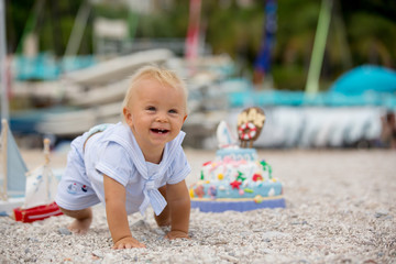 Fototapeta na wymiar Sweet baby boy, celebrating first birthday with sea theme cake and decoration