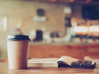 hot coffee on wooden table with sun light morning  from the window 