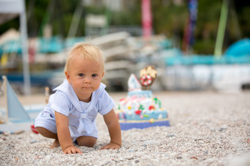 Sweet baby boy, celebrating on the beach first birthday with sea theme cake