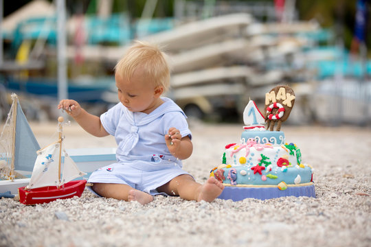Sweet baby boy, celebrating on the beach first birthday with sea theme cake