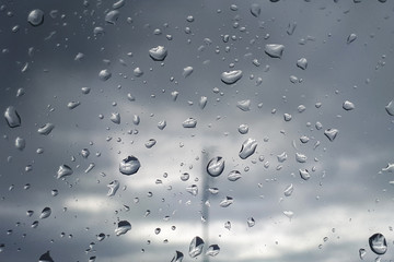 Rain on a gloomy day. Water drops on the window. Drops of rain on the glass at home.