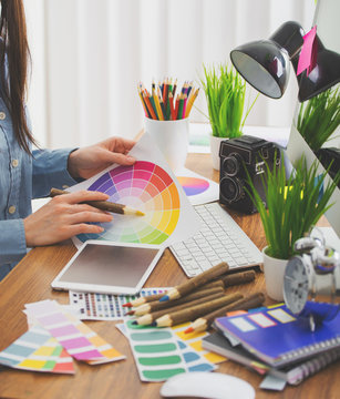 Young cute Graphic designer using graphics tablet to do his work at desk