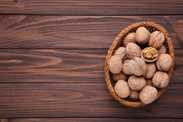 Walnuts kernels in basket on brown wooden background. Walnuts kernels on grey wooden table