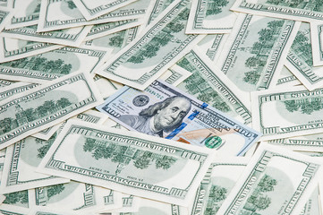 Background from dollars. Notes of one hundred American dollars are scattered across the background.