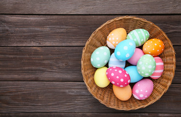 Obraz na płótnie Canvas Colorful easter eggs in basket on grey background