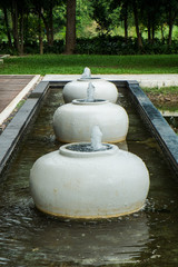 Fountain from water jar decoration in the pool