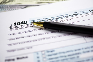 Tax Return form 1040 and dollar banknote : U.S. Individual Income.