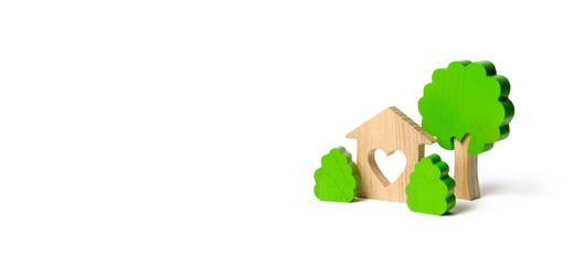 A house with a heart and wooden figures of trees with bushes on an isolated background. love nest. Acquisition of affordable housing in a mortgage or loan. Accommodation for families. Banner