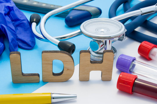 LDH Medical lab acronym, meaning lactate dehydrogenase. Letters that make word of LDH, located near test tubes with blood, stethoscope and other diagnostic tools and devices, latex gloves