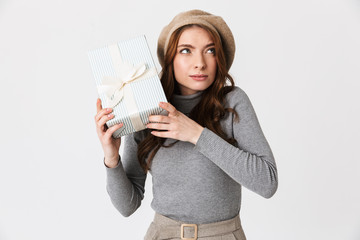 Photo of curious woman 30s wearing hat holding present box