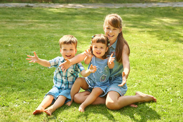 Naklejka na ściany i meble happy playful children outdoors in the summer on grass in a backyard