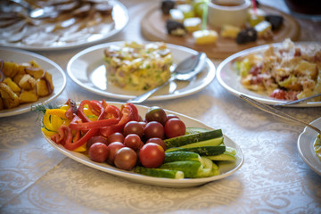 healthy salad with fresh ripe summer vegetables , tomato, cucumber , radishes , spices and white toast on a wooden background