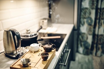 Chinese tea Pu-erh in a modern kitchen interior, a classic tea ceremony in pottery on a wooden podium