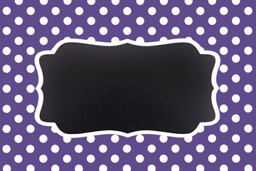 classic ultra violet background with symmetrical white polka dots and an empty chalkboard for text © Martina