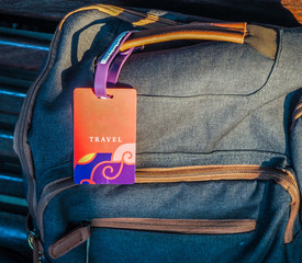 Naklejka premium Hipster green backpack and travel label. View from front tourist traveler bag on Iron bench